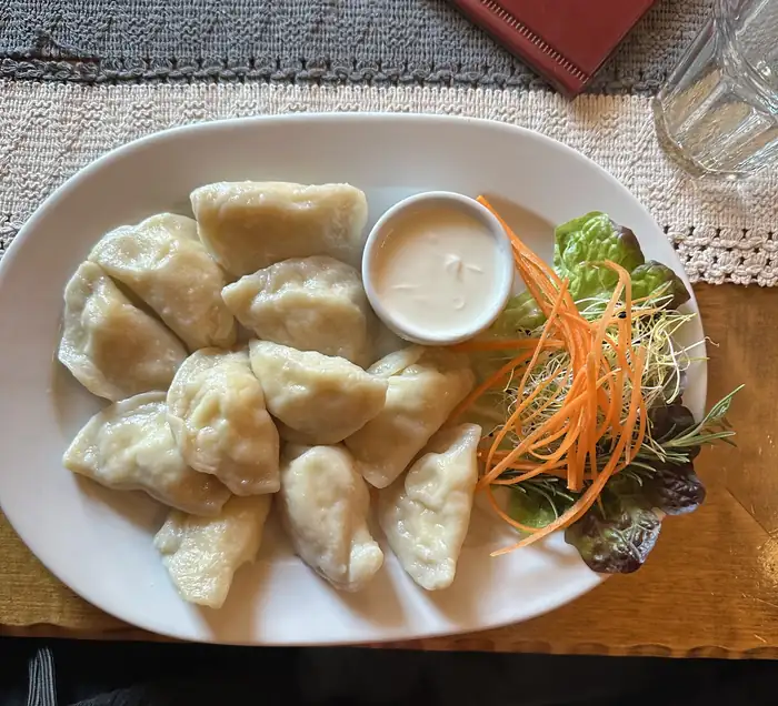 Pierogi z sosem i surówką na talerzu